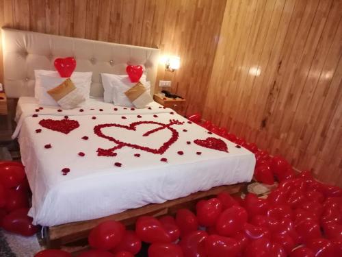 a bedroom with a bed with red hearts on it at white coral beach resort in Havelock Island