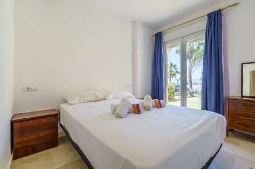 a bedroom with a large white bed with a window at CT 184 - Atalaya del Sol in Mijas Costa