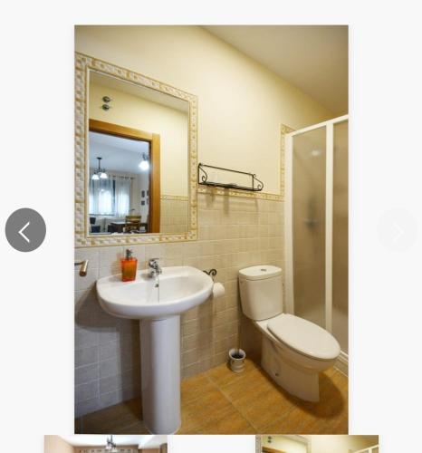 uma casa de banho com um lavatório, um WC e um espelho. em Estudio con cocina y baño privado em Jarandilla de la Vera
