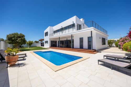 a house with a swimming pool in front of it at Pontalaia Village in Sagres