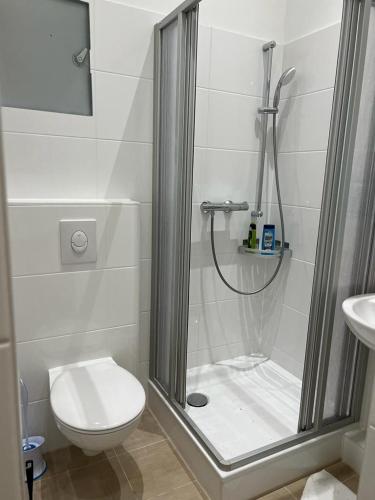 a bathroom with a shower with a toilet and a sink at Pension Lotti Friedrichshain in Berlin