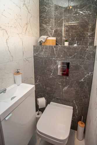 a bathroom with a white toilet and a sink at Apartament Panorama in Warsaw