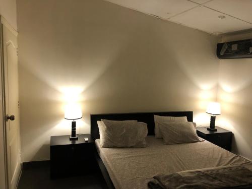 a bedroom with a bed with two lamps on it at Fully Luxurious Entire Villa Vacation Home In Bahria Town Phase 8 in Rawalpindi
