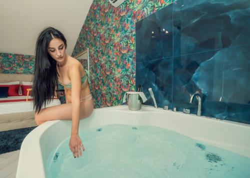 Una donna è seduta in una vasca da bagno di Beneduce B&B ROOMS a Santa Maria di Castellabate