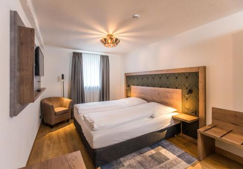 a bedroom with a large bed and a chair at Hotel-Restaurant Heiligenstadter Hof in Heiligenstadt