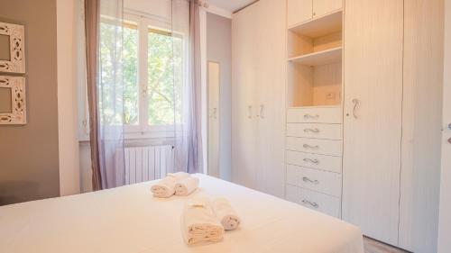 ein weißes Schlafzimmer mit Handtüchern auf dem Bett in der Unterkunft La Casa sulla Collina - Italian Homing in Padenghe sul Garda