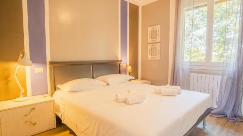 Un dormitorio con una cama blanca con toallas. en La Casa sulla Collina - Italian Homing, en Padenghe sul Garda