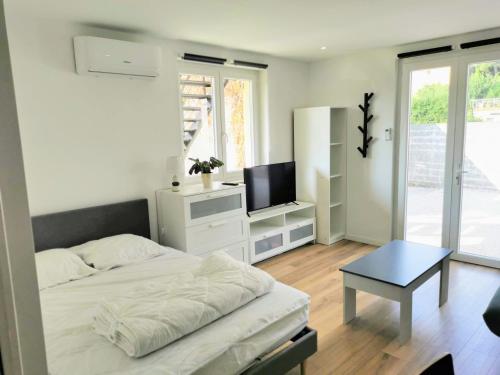 une chambre avec un lit, une télévision et une table dans l'établissement Appartement climatisé Golfe-Juan plage, à Vallauris