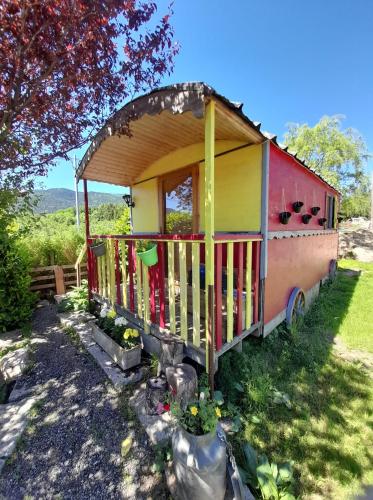 a tiny house with a porch in a yard at Le Ranch du Madres in Roquefort-de-Sault