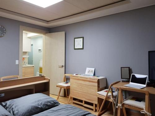 um quarto com uma cama e uma secretária com um computador portátil em Gyeongbokgung Palace Seochon Christian Home - Foreigner Only em Seul