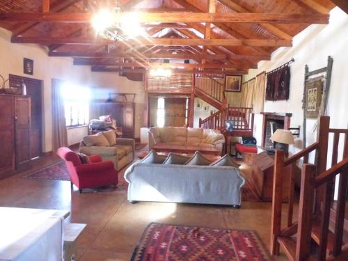 een grote woonkamer met een bank en stoelen bij Cedarwood Guest House in Howick