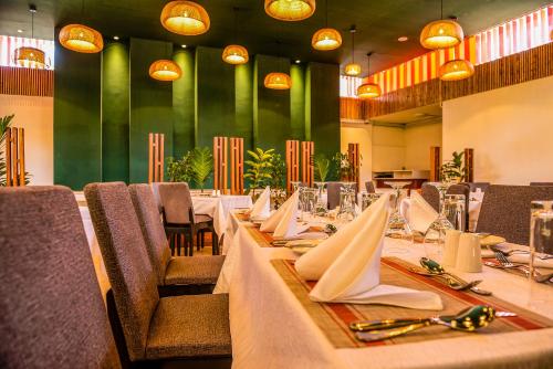 uma sala de jantar com mesas longas e cadeiras com guardanapos em Hotel Boulevard Nairobi, City Centre CBD em Nairobi