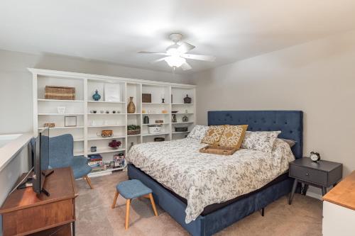 a bedroom with a bed and a tv and shelves at Modern Cozy Townhome in Charlotte