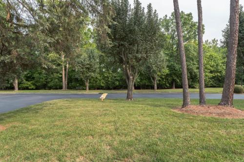 a park with a bench in the grass next to a road at Modern Cozy Townhome in Charlotte