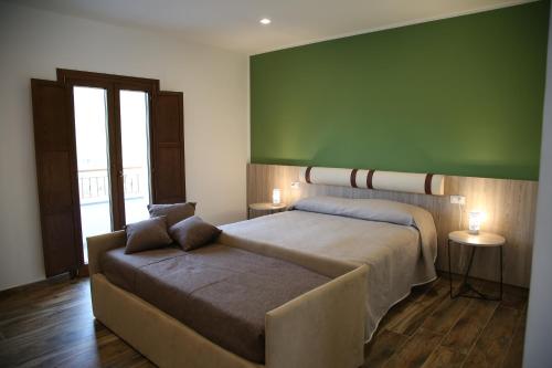 um quarto com uma cama e um sofá com uma parede verde em Azienda Agricola Ausono em Piaggine