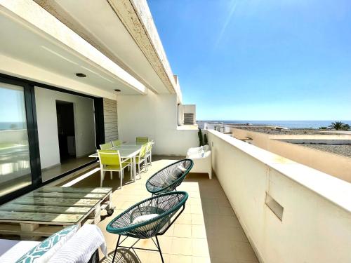 a balcony with chairs and a table and the ocean at Moderno apartamento con vistas al mar in Las Negras