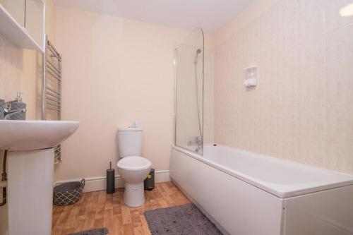 a white bathroom with a toilet and a sink at Lovely 1 bed apart.Contractors.NearRussellHillHosp in Brierley Hill