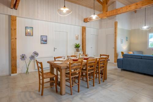 une salle à manger avec une table et des chaises en bois dans l'établissement Les Gîtes de Sophie 85 Gîte Agapanthe, à Saint-Gervais