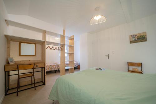 une chambre avec un lit, un bureau et un miroir dans l'établissement Les Gîtes de Sophie 85 Gîte Agapanthe, à Saint-Gervais