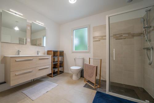 une salle de bain avec toilettes et douche en verre dans l'établissement Les Gîtes de Sophie 85 Gîte Agapanthe, à Saint-Gervais