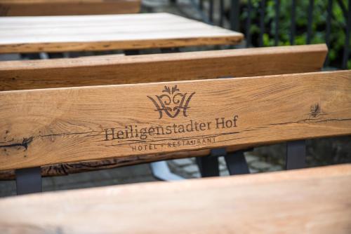 a wooden bench with a hartcliffe hot sign on it at Hotel-Restaurant Heiligenstadter Hof in Heiligenstadt