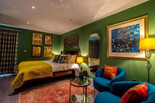 a bedroom with green walls and a bed and chairs at The Boutique York Garden Studio in York