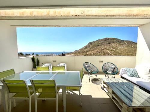 a balcony with a table and chairs and a mountain at Moderno apartamento con vistas al mar in Las Negras
