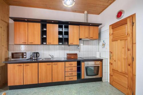 una cucina con armadi in legno e piano di lavoro nero di Apartament Limba a Zakopane