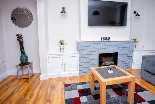 a living room with a fireplace and a tv at First house in Kettering