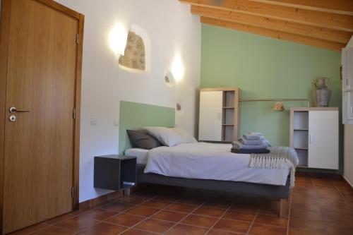 a bedroom with a bed in a room at Casa do Bairro - A Gema escondida da Santa Catarina da Fonte do Bispo in Santa Catarina da Fonte do Bispo