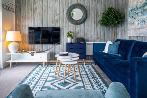 a living room with a blue couch and a table at Apartment 4, Hunstanton in Hunstanton