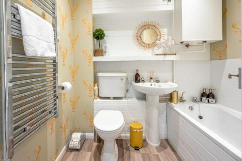 een badkamer met een toilet, een wastafel en een bad bij Apartment 4, Hunstanton in Hunstanton