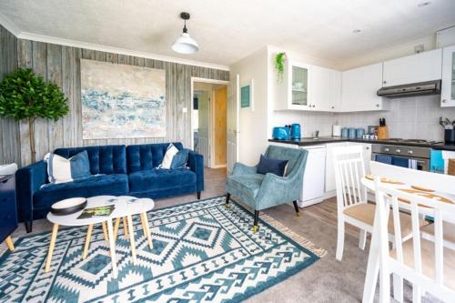 a living room with a blue couch and a kitchen at Apartment 4, Hunstanton in Hunstanton