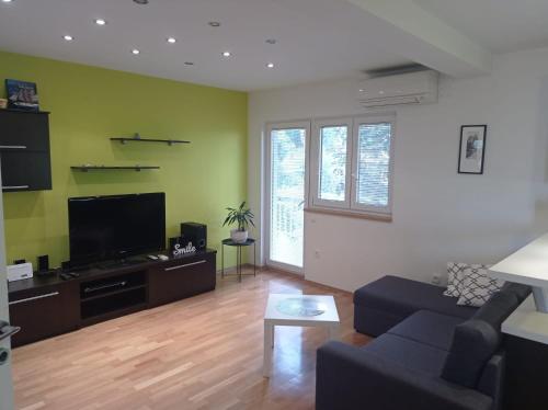 a living room with a couch and a flat screen tv at Apartment Petar - by the Sea in Gradac