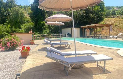 a group of chairs and umbrellas next to a pool at Residence Mancini - Cilento Home & Sunset in Rocca Cilento