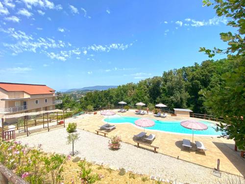 a pool with chairs and umbrellas in a resort at Residence Mancini - Cilento Home & Sunset in Rocca Cilento