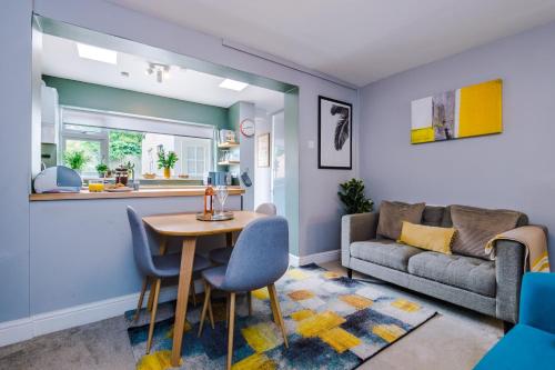 een woonkamer met een tafel en een bank bij Perfectly Located House with All Necessities in Cheltenham