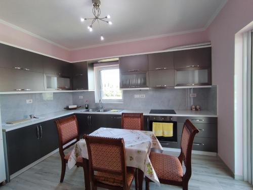 uma cozinha com mesa e cadeiras e uma cozinha com fogão em Cheerful 2 bedroom villa with free parking. em Gjirokastër