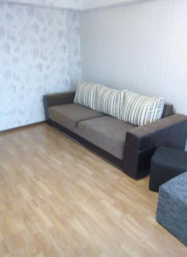 un sofá en una sala de estar con suelo de madera en квартира в районі автовокзалу, en Rivne