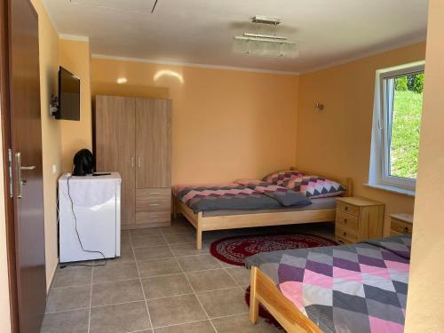 a bedroom with two beds and a refrigerator at Bajkowe Mazury Domek Wakacyjny in Mikołajki