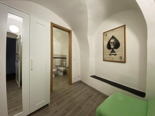 um corredor com uma cadeira verde e uma casa de banho em LA CASA DEL BORGO nature sport & relax Big Loft em Calice Ligure
