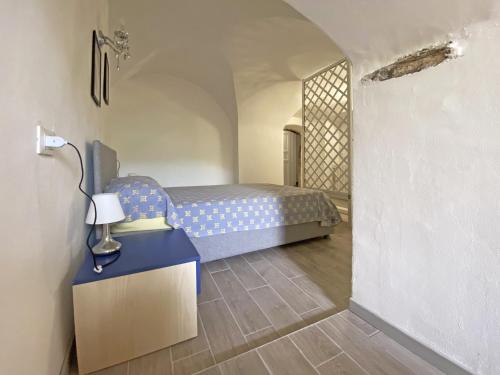 um quarto com uma cama e uma mesa com um candeeiro em LA CASA DEL BORGO nature sport & relax Big Loft em Calice Ligure