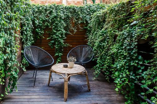two chairs and a table on a wooden deck at Hotel Well and Come Barcelona in Barcelona