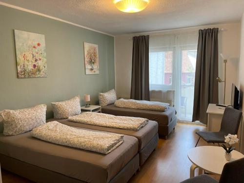 um quarto de hotel com duas camas e um sofá em TOP LAGE 2 Zimmerwohnung mit Balkon und bester Aussicht in OG 2 links em Rostock