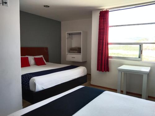 a hotel room with two beds and a window at Hotel Euro Confort,Pachuca in Pachuca de Soto