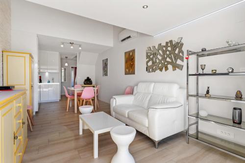 un salon avec un canapé blanc et une table dans l'établissement Villa Néréides Héliovillage, village naturiste, 45m2,chambre en rez de chaussée avec dressing, au Cap d'Agde