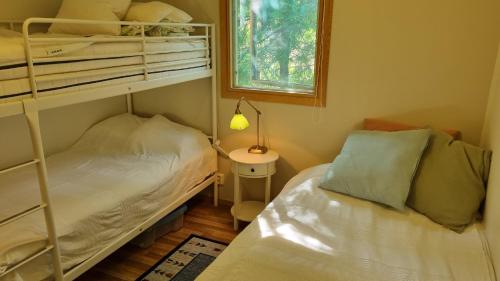um quarto com 2 beliches e uma janela em Fritidshus Rostockvägen 40B - Guest House - Bring own bed sheets em Norrtälje