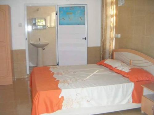 1 dormitorio con cama, lavabo y puerta en Albamauritius B&B, en Belle Mare