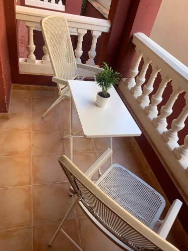 uma mesa e cadeiras numa escada com uma planta em Apartamento Puerto II em Mazagón