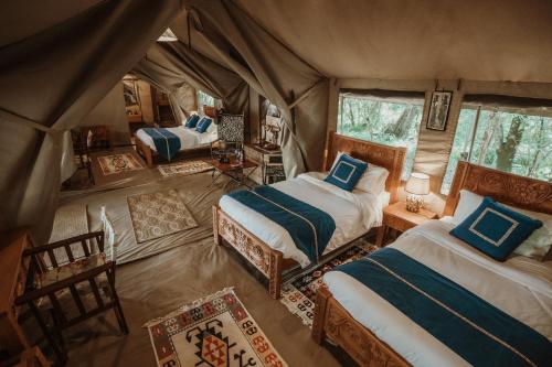 a bedroom with two beds in a tent at Mara Olapa Camp in Masai Mara